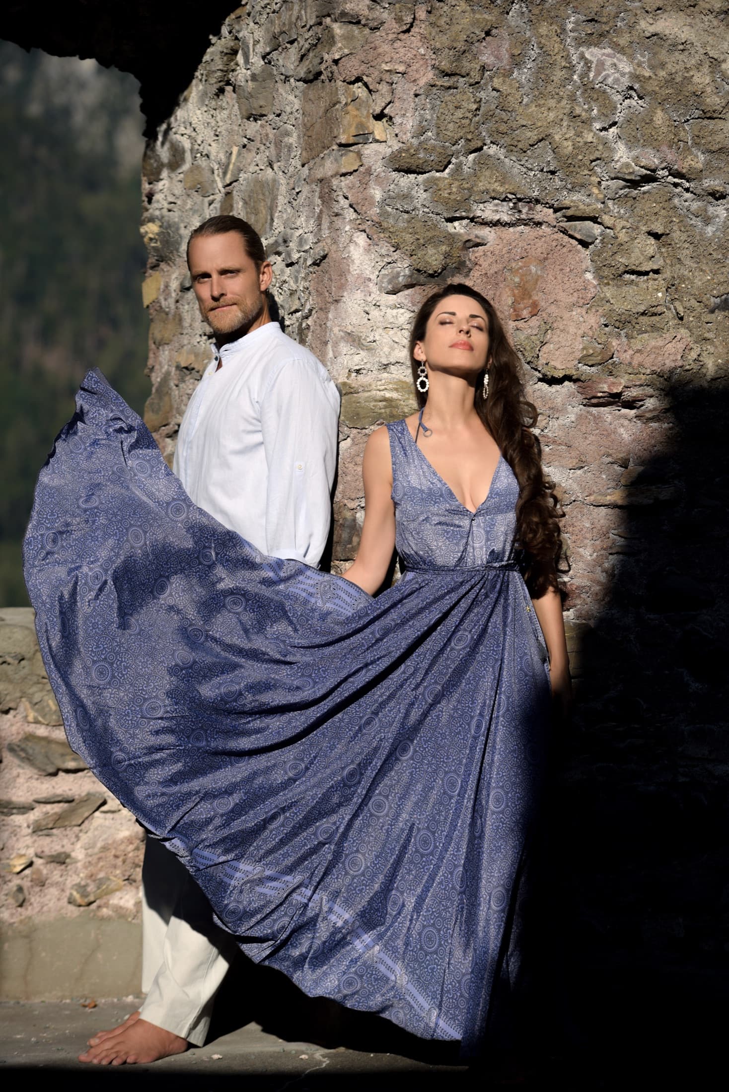 Jason and partner in a sacred portrait beside a stone wall