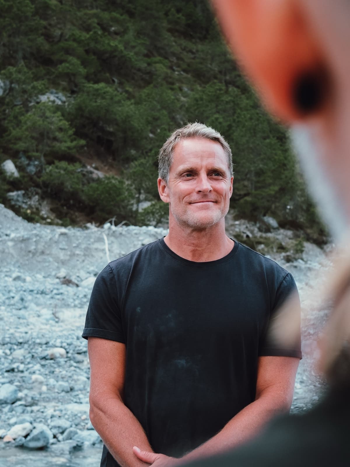 Jason Milne smiling, outdoor mountain backdrop